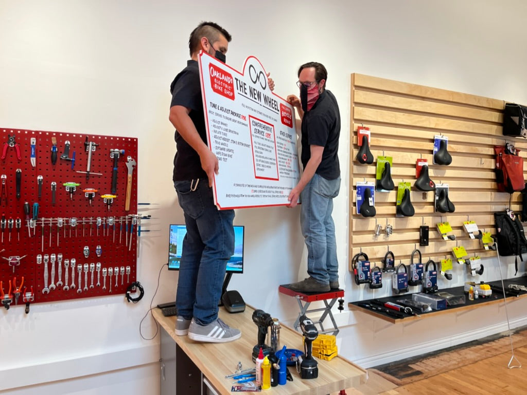 installing the bicycle service sign at The New Wheel electric bikes Oakland